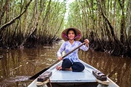 Una mujer con su barca en Tra Su, el delta del Mékong en Vietnam